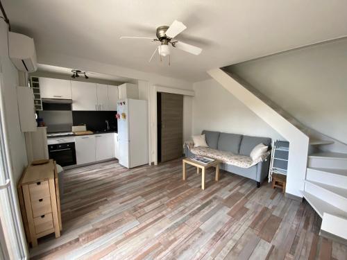 Il comprend une cuisine et un salon avec un ventilateur de plafond. dans l'établissement VILLAGE DE LA MER, à La Londe-les-Maures