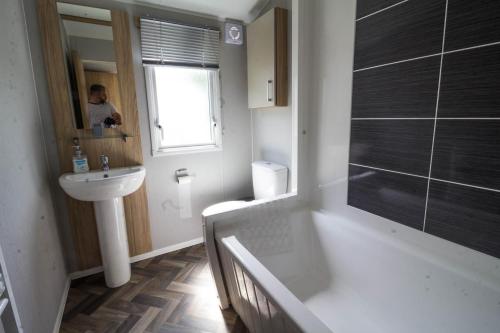 a bathroom with a sink and a toilet and a mirror at Beautiful 6 Berth Caravan At Southview Holiday Park In Skegness Ref 33031s in Skegness