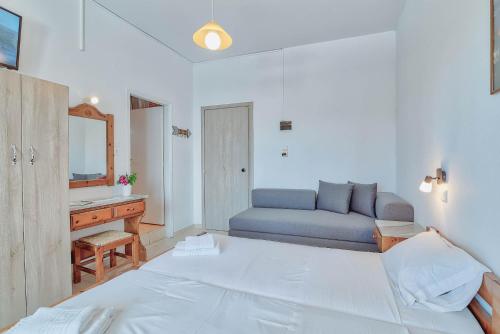 a bedroom with a bed and a desk and a mirror at Pavlos Place in Antiparos Town