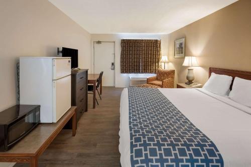 una camera d'albergo con un grande letto e una scrivania di Rodeway Inn a Brazil