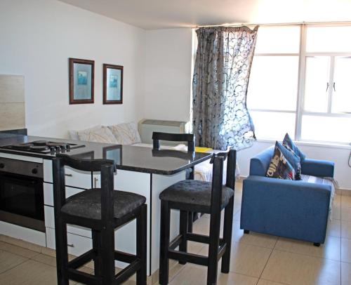 a kitchen and living room with a table and chairs at Unit 104 @Tenbury in Durban