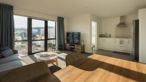 a living room with a couch and a table and a kitchen at Entire Unit - 18 Rodman - newly furnished in Lake Tekapo