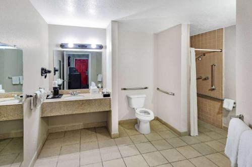 a bathroom with a toilet and a sink and a shower at Howard Johnson by Wyndham Houston Hobby Airport in Houston