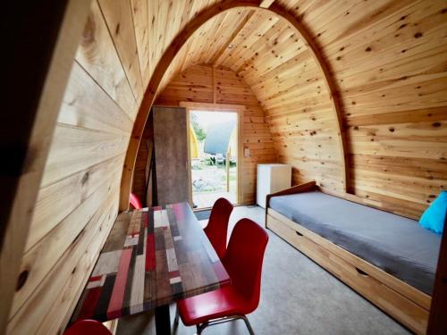 Holzhütte I21 groß في رايشناو: غرفة مع طاولة وكراسي وسرير