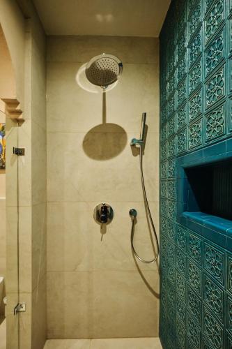 a shower in a bathroom with a blue tiled wall at Kosh Havuz boutique hotel in Samarkand