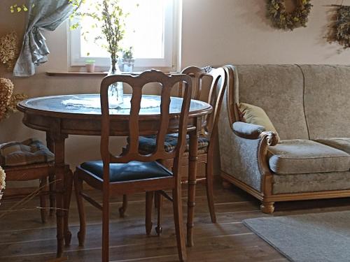 - une table à manger avec des chaises et un canapé dans l'établissement Zielona Dolina, à Lewkowo