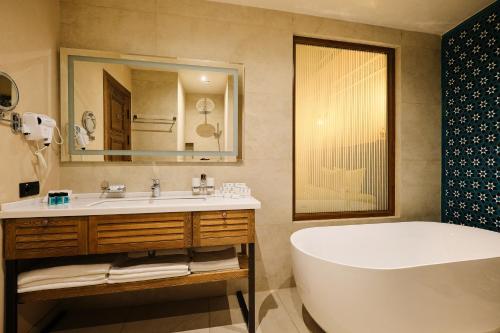 Kosh Havuz boutique hotel في سمرقند: حمام مع حوض ومغسلة