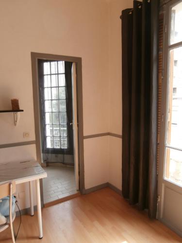 Cette chambre comprend une porte, une table et une fenêtre. dans l'établissement Studio Climatisé dans villa bourgeoise, à Nice