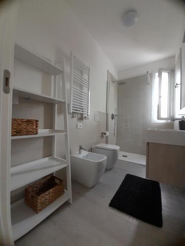 La salle de bains blanche est pourvue d'une baignoire, de toilettes et d'un lavabo. dans l'établissement Ca' Savio terramare, à Cavallino-Treporti