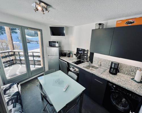 a kitchen with a table and a counter top at STUDIO CENTRE STATION - REFAIT A NEUF 4 PERSONNES in Laveissière