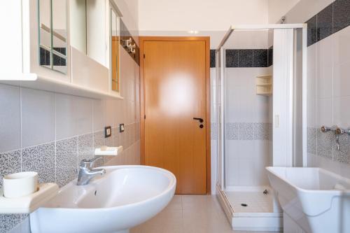 アルカモ・マリーナにあるDonnarè Apartmentsのバスルーム(白いシンク、シャワー付)