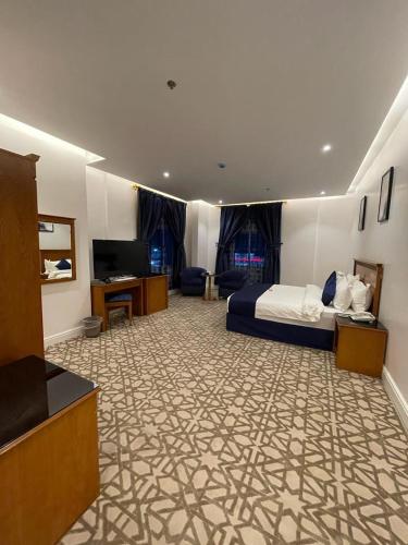 a hotel room with a bed and a television at Diyafat Al Saada Residential Units -Hafr Abatin in Abū Qa‘ar