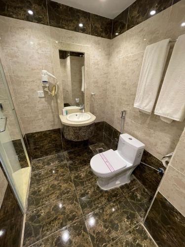 a bathroom with a toilet and a sink at Diyafat Al Saada Residential Units -Hafr Abatin in Abū Qa‘ar