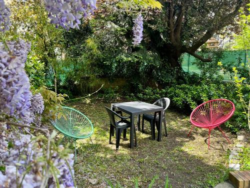3 chaises et une table dans un jardin dans l'établissement Studio indépendant dans maison individuelle, à Nancy