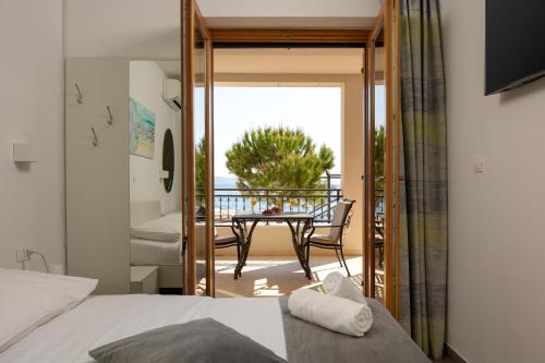 a bedroom with a view of a table and a balcony at Apartments Lea in Podstrana