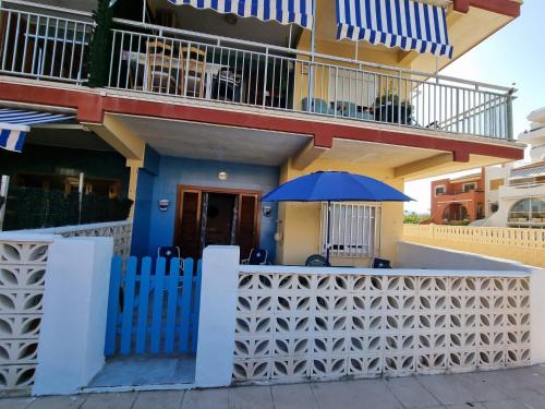 a blue umbrella sitting outside of a house at Bonsol Solo Familias Serviplaya in Playa de Xeraco