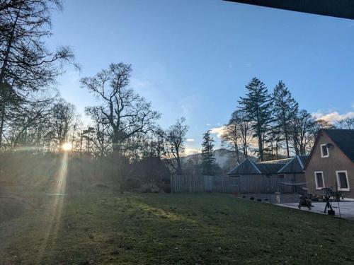 a view of a yard with the sun in the sky at Westmains Lodge in Callander
