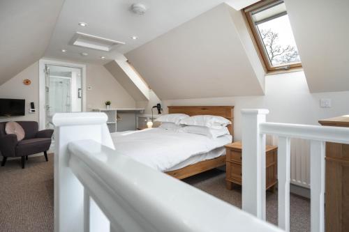 a white bedroom with a bed and a window at Westmains Lodge in Callander