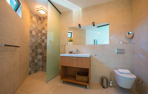 a bathroom with a sink and a toilet and a mirror at Korcula Hill in Korčula