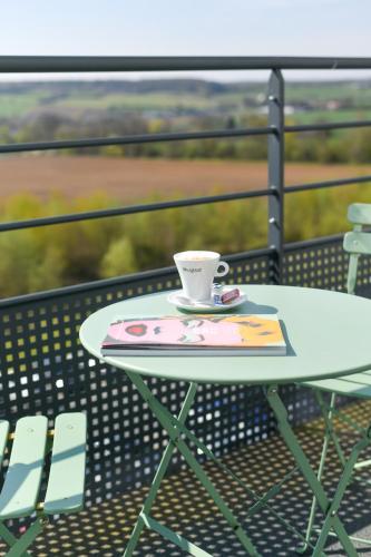 a coffee cup sitting on a table on a balcony at ibis Styles Namur in Namur