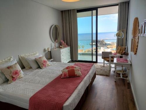 a bedroom with a bed with a view of the ocean at Stunning Lobos View in Câmara de Lobos