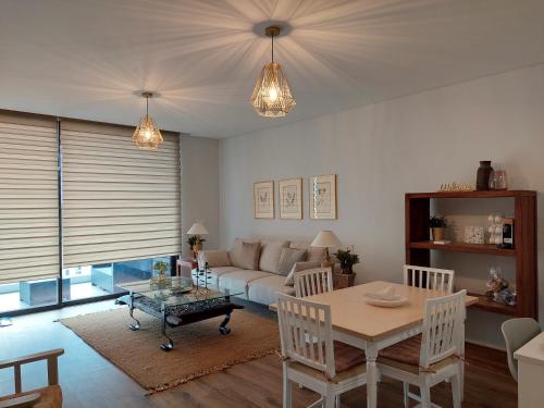a living room with a table and a couch at Stunning Lobos View in Câmara de Lobos