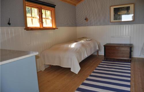 a bedroom with a bed and a table and a window at Cozy Home In Långserud With Jacuzzi in Rullan