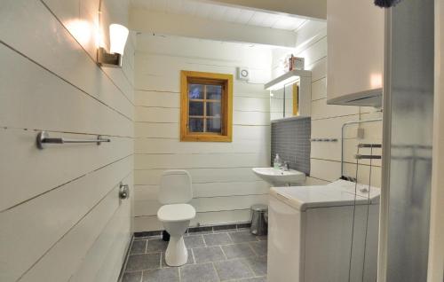uma casa de banho branca com um WC e um lavatório em Stunning Home In Lngserud With 3 Bedrooms, Jacuzzi And Sauna em Rullan