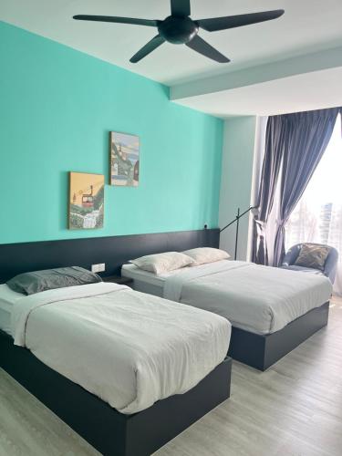 2 Betten in einem Zimmer mit Deckenventilator in der Unterkunft Emerald Avenue Cozy 3R3B Apartment 716 in Brinchang