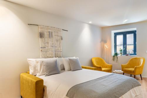 um quarto com uma cama grande e 2 cadeiras em Sé Apartamentos - São Sebastião Apartment em Braga