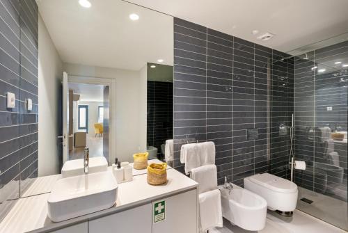a bathroom with a sink and a toilet and a mirror at Sé Apartamentos - São Sebastião Apartment in Braga