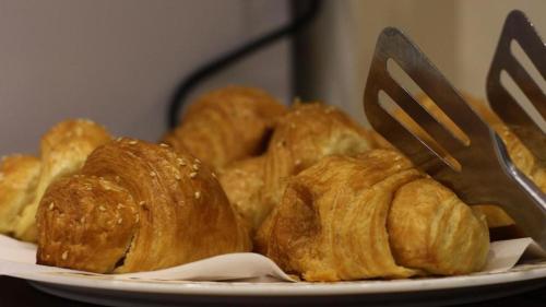 a plate of croissants and a fork and knife at Al Farhan Hotel & Suites Hafr Al Batin in Abū Qa‘ar