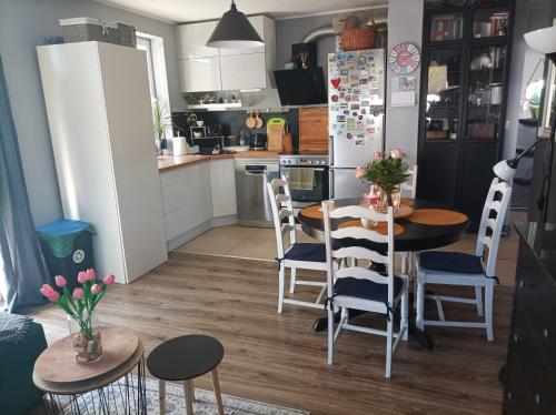 eine Küche und ein Esszimmer mit Tischen und Stühlen in der Unterkunft Atrakcyjny apartament z dużym ogrodem in Danzig