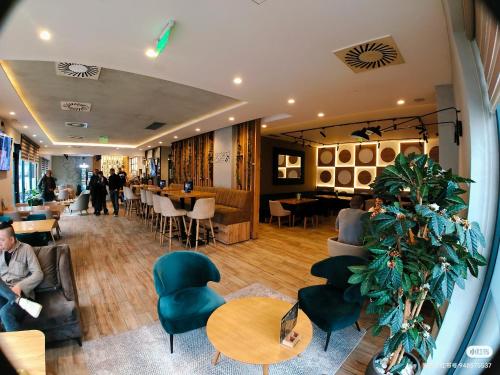 a lobby of a restaurant with tables and chairs at H.T Hotel in Belgrade