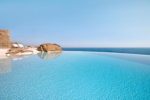 a swimming pool with the ocean in the background at Liberation Villa in Kalafatis