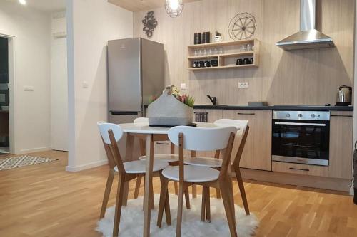 La cuisine est équipée d'une table, de chaises et d'un réfrigérateur. dans l'établissement Sarajevo New Apartments, à Sarajevo