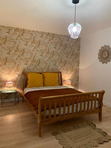 - une chambre avec un lit en bois et 2 oreillers jaunes dans l'établissement Gîte du Triskell Le Domaine de Coat Rogan, à Pommerit-Jaudy