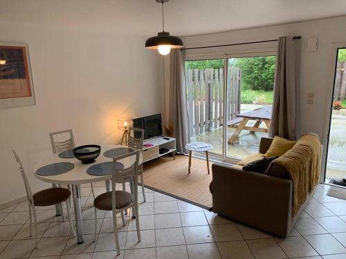 un salon avec une table et un canapé dans l'établissement Gîte du Triskell Le Domaine de Coat Rogan, à Pommerit-Jaudy