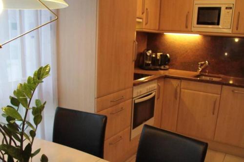 a kitchen with wooden cabinets and a table and chairs at Château 11 in Leukerbad