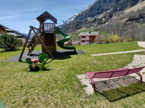 a playground with a slide in the grass at Château 11 in Leukerbad