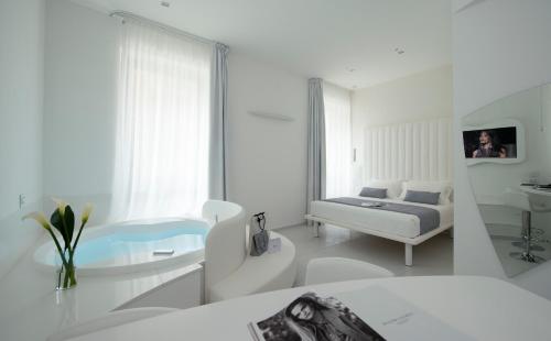 Mia Boutique Hotel في ميلانو: غرفة بيضاء مع سرير ومغسلة