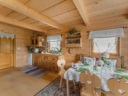 a dining room with a table in a cabin at Domek Regionalny Bąkowo Chatka in Witów