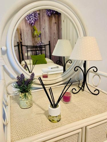 a bedroom with a white bed with a mirror at El Nido Frigiliana - Cortijo Rosalia in Frigiliana