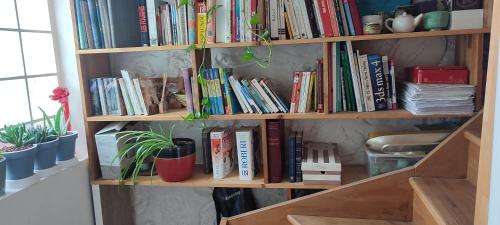 a book shelf filled with books in a room at Logement calme et ensoleillé dans maison de ville in Villejuif