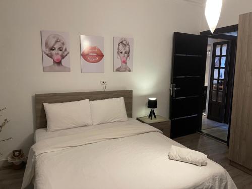 a bedroom with a bed with four pictures on the wall at Modern luxury apartment in Cairo