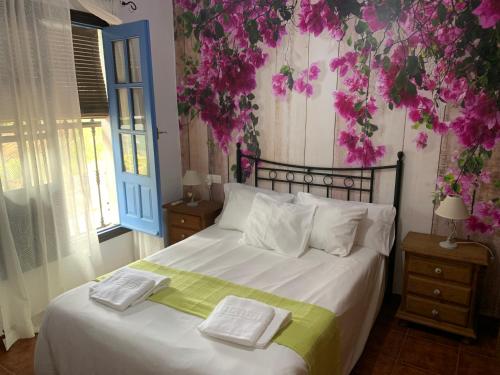 een slaapkamer met een bed met twee handdoeken erop bij Villa en Frigiliana con Piscina y Jacuzzi in Frigiliana
