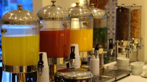 a group of three blenders filled with different colored liquids at Al Farhan Hotel & Suites Hafr Al Batin in Abū Qa‘ar