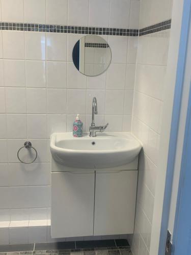 a white bathroom with a sink and a mirror at Hotel Flevo in Zeewolde