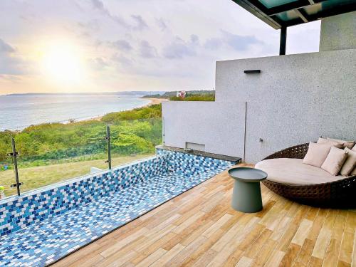 a balcony with a couch and a view of the ocean at Kenting Sea Wall 130 in Kenting