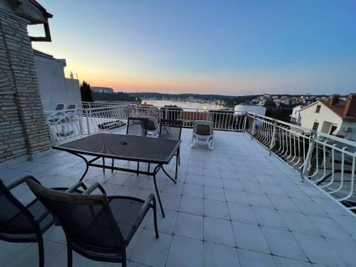 a patio with a table and chairs on a balcony at Apartments By The Sea in Pula
